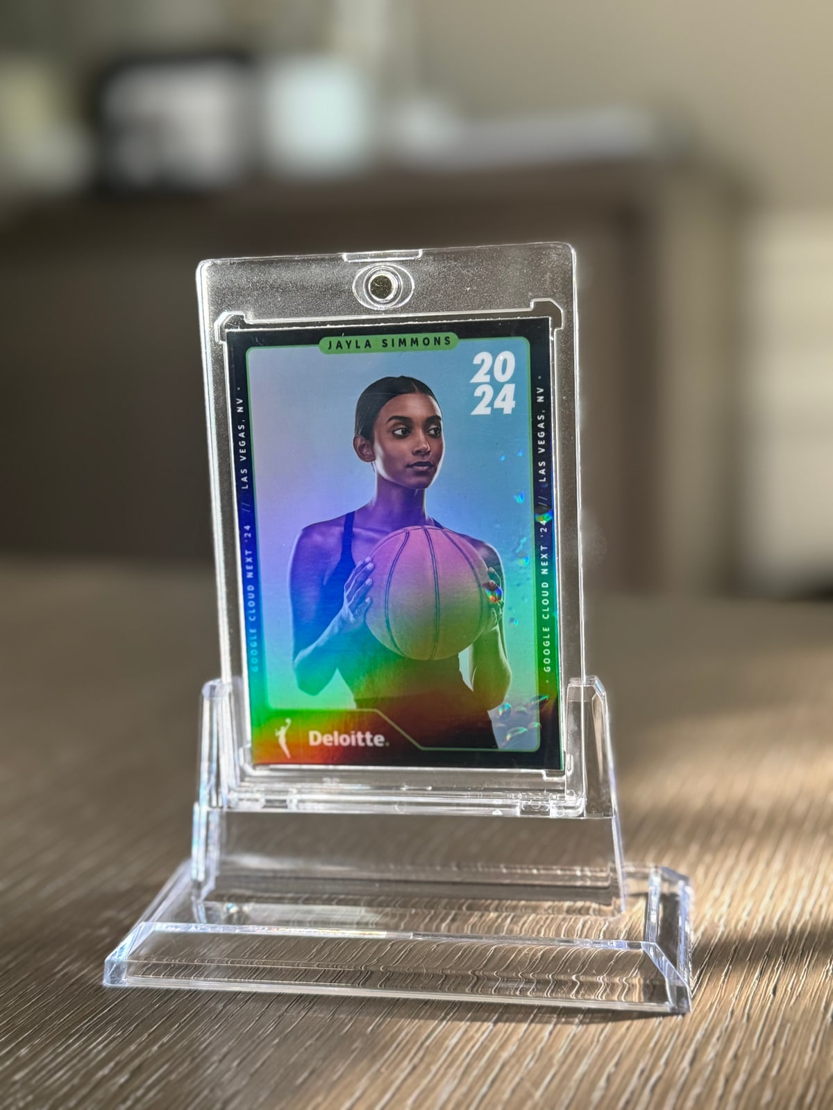 Holographic basketball portrait card with Deloitte artwork inside a clear display case