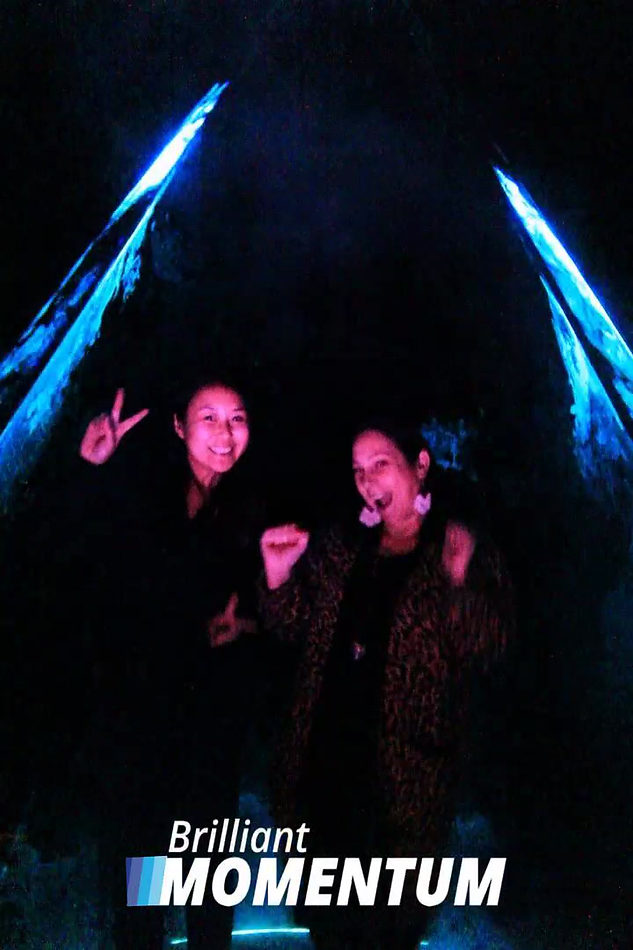 Guests posing inside the vertical laser canopy for an overhead capture