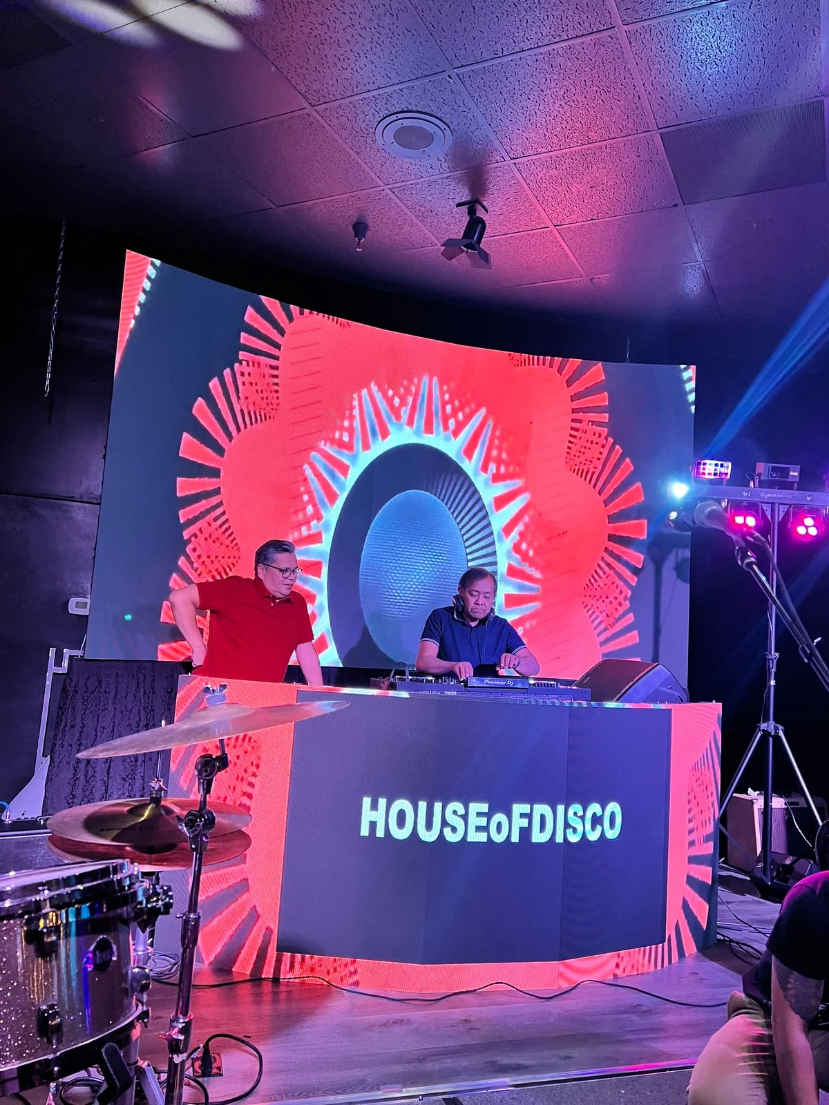 DJs performing in front of coordinated LED screen and booth-front visuals
